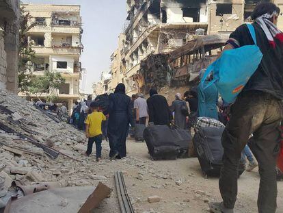 Esta imagen, cedida por activistas antigubernamentales de Siria, muestra la evacuación de civiles de la localidad sitiada de Daraya, al suroeste de Damasco.