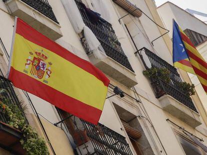 Bandera espa&ntilde;ola y bandera catalana estelada independentista en un edificio de Barcelona