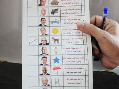 Un hombre sostiene una boleta para votar en las presidenciales egipcias.