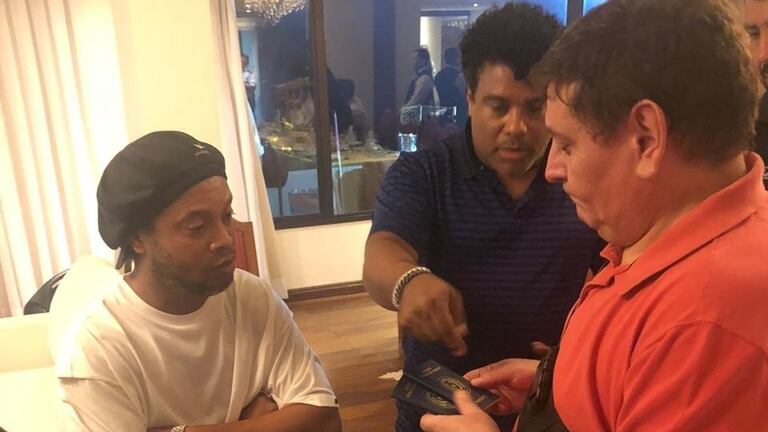 Autoridades policiales en la habitación de Ronaldinho, a la izquierda en Lambaré, Paraguay.
