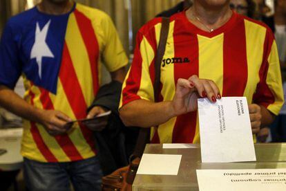 Una ciudadana deposita su voto en una mesa de en un colegio electoral de Barcelona.
