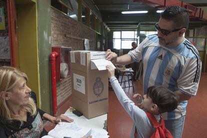 Un hombre vota con su hijo en Villa Lugano.