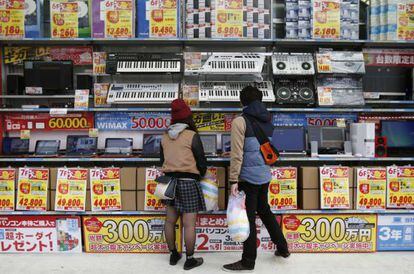 Dos jóvenes miran una tienda en Tokio este domingo.