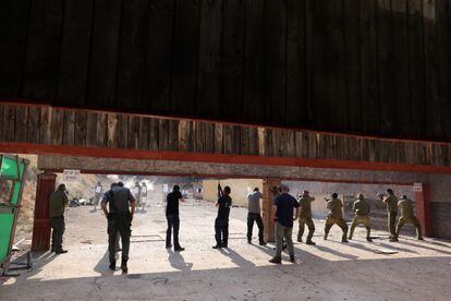 Civiles israelíes practican con armamento en un punto de distribución en Ayyelet HaShahar, al norte de Israel, cerca de la frontera con el Líbano. 