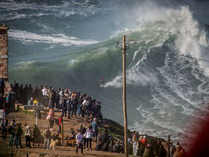 Un grupo de personas observaba a los surfistas en la temporada de olas gigantes de Nazaré, Portugal, en 2022.