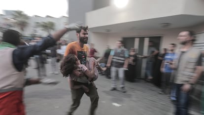 Un hombre traslada al hospital Al Shefa a una niña herida en un bombardeo israelí , el pasado 11 de octubre. 
