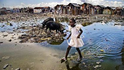 La imagen de una niña haitiana caminando descalza entre charcos de barro y mugre en un barrio de chabolas de Puerto Príncipe, ganadora del premio de fotografía Unicef 2009.