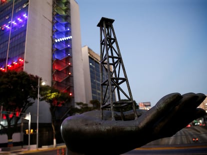 Una escultura representa una torre de petróleo en una mano cerca de las oficinas de PDVSA, en Caracas (Venezuela).