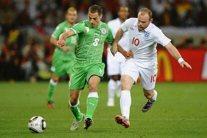 Wayne Rooney, la estrella de Inglaterra, corre tras un balón junto al argelino Mehdi Lacen.