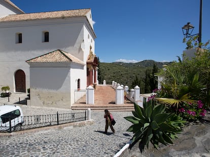 Un vecino pasea junto a la iglesia de Macharaviaya, en Málaga, pueblo sin casos positivos de coronavirus.