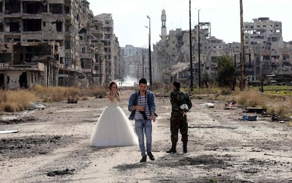 VIDA MÁS ALLÁ DE LA GUERRA. Dos recién casados sirios, Nada Merhi, de 18 años, y el soldado del régimen Hassan Youssef, de 27, posan el viernes para sus fotos de boda en mitad de la destrucción de Homs. El fotógrafo dice que quiere reflejar que la vida es más fuerte que la muerte.