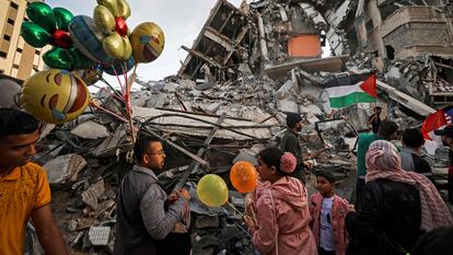 Un hombre palestino vende globos frente a un edificio destruido por los ataques aéreos israelíes, este viernes en Gaza.