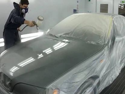 Un operario pintando un coche.