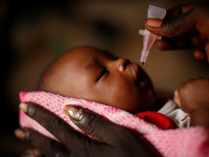 Un bebé es sostenido por su madre mientras recibe la vacuna oral de la polio en Rubkona (Sudán del Sur), en 2011.