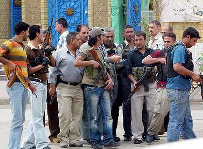 Un grupo de suníes armados escolta a un dirigente tribal hasta la mezquita de Abu Hanifa, en Bagdad.