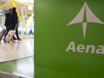 Dos pasajeros pasan ante un expositor de Aena en el aeropuerto madrile&ntilde;o de Barajas. / Reuters