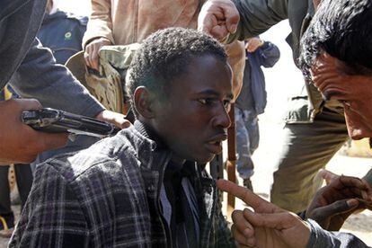 Rebeldes acusan a un joven, a punta de pistola, de ser un leal a Gadafi.