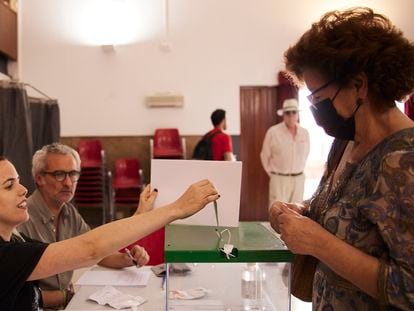 La presidenta de una mesa mete un voto en la urna el día de las elecciones andaluzas en un colegio electoral de Sevilla.