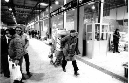 Un trabajador lleva una carretilla por el pasillo frutas y hortalizas de Mercamadrid en una imagen histórica sin datar.