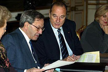 Chirac recibe el informe de manos de Bernard Stasi.