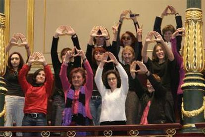Un grupo de mujeres hace el saludo feminista desde la tribuna de invitados del Congreso tras la aprobación de la ley.