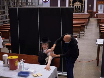 Un ultraortodoxo se vacuna contra la covid, el domingo en una sinagoga de Bnei Brak (Israel).