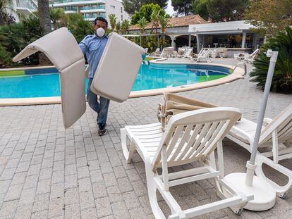 Un trabajador del hotel Riu Bravo de la playa de Palma (Baleares) prepara las zonas exteriores del complejo turístico.