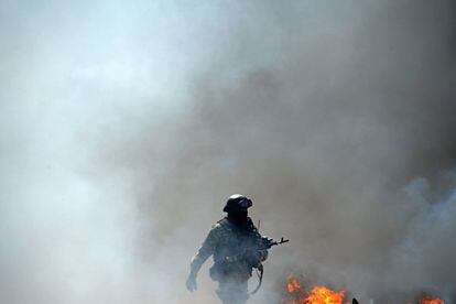 Un soldado ucranio pasa ante un puesto de control incendiado por fuerzas prorrusas en Slaviansk.