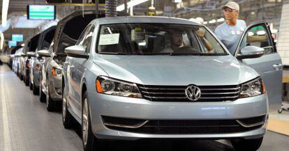 Una operaria comprueba el acabado de un coche de Volkswagen.