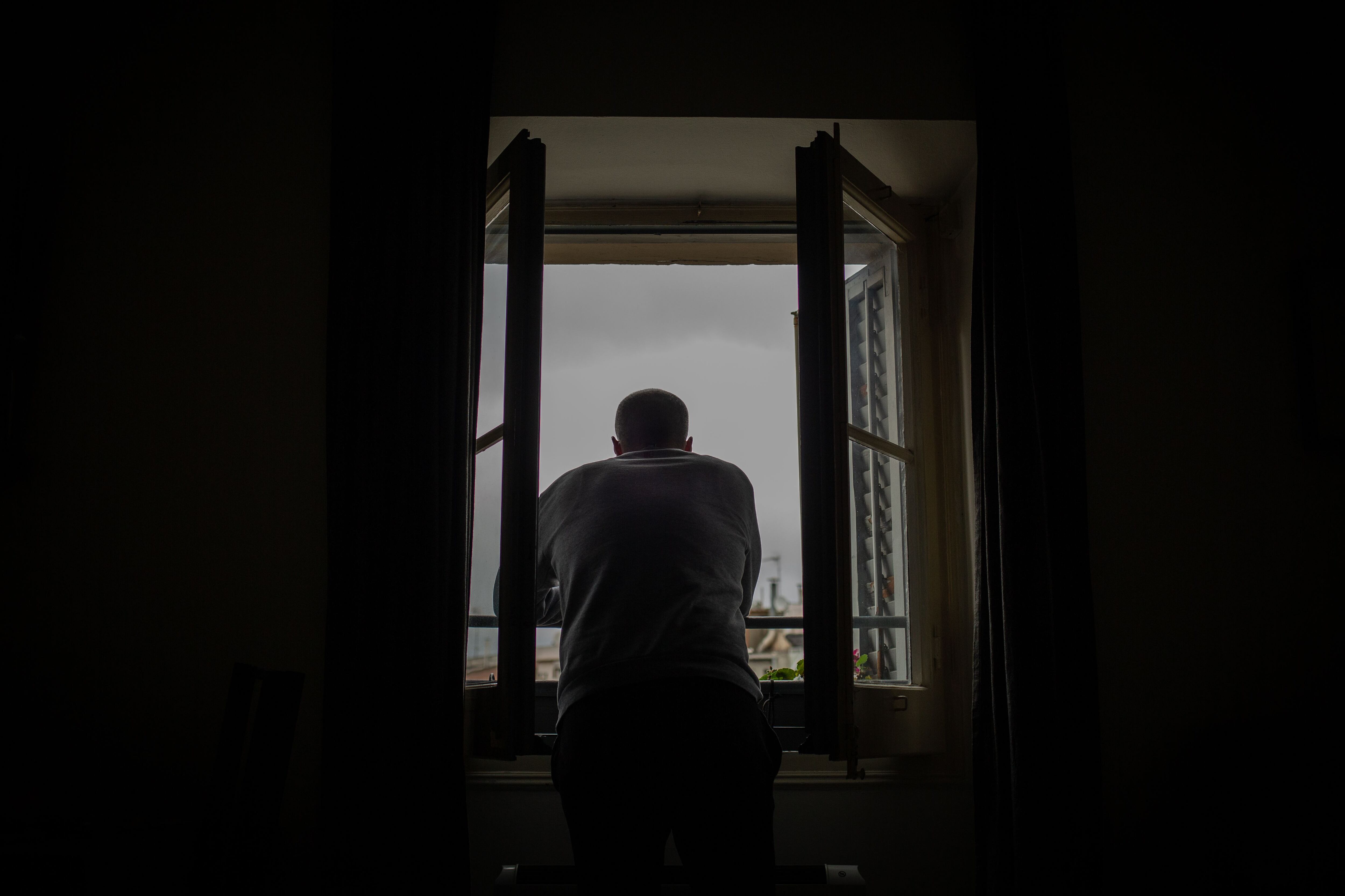 Una persona se asoma a la ventana durante el confinamiento, en Barcelona, en marzo de 2020.