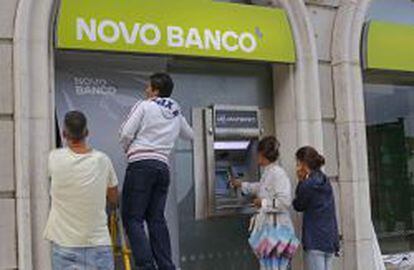 Trabajadores instalan el nuevo logo de Novo Banco en una oficina de Lisboa.