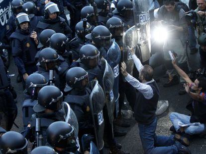 Manifestantes se enfrentan a un nutrido despliegue policial al lado de Congreso de los Diputados. 