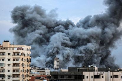 Una columna de humo se eleva sobre algunos edificios atacados por Israel en Gaza, este sábado.