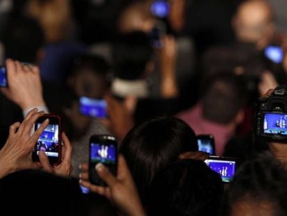 Un grupo de personas graba vídeos con sus móviles.