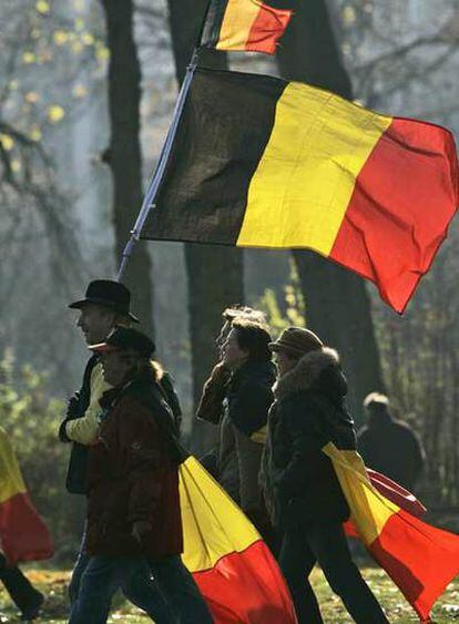 Manifestantes favorables a la unidad belga marchan en Bruselas con la bandera del país.