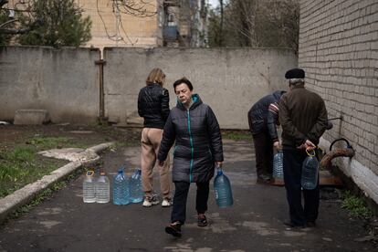 Several neighbors fill water bottles in Avdiivka this Saturday.