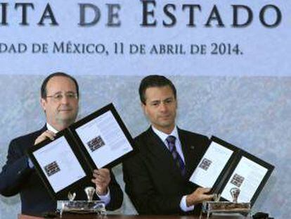 El presidente de Francia, François Hollande (i), y su homólogo de México, Enrique Peña Nieto (d), muestran la cancelación de un timbre postal hoy, viernes 11 de abril de 2014, durante el Encuentro Económico Franco-Mexicano realizado en Ciudad de México. EFE/Archivo