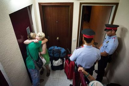 Irene Sánchez llora y se abraza a una vecina del edificio del que acaba de ser desahuciada, junto a sus tres hijos y su madre Mari Carmen Giménez, en la calle Alts Fons 61 de Barcelona.