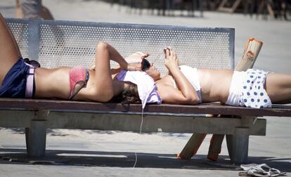 Noies en un banc a Barcelona, durant una onada de calor.