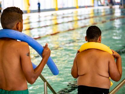 Dos niños practican actividades acuáticas en una piscina de Berlín.