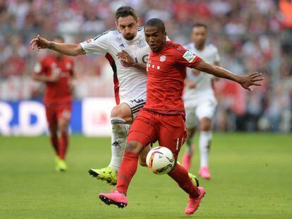  Douglas Costa se lleva un balón ante el acoso de Hilbert del Bayer Leverkusen