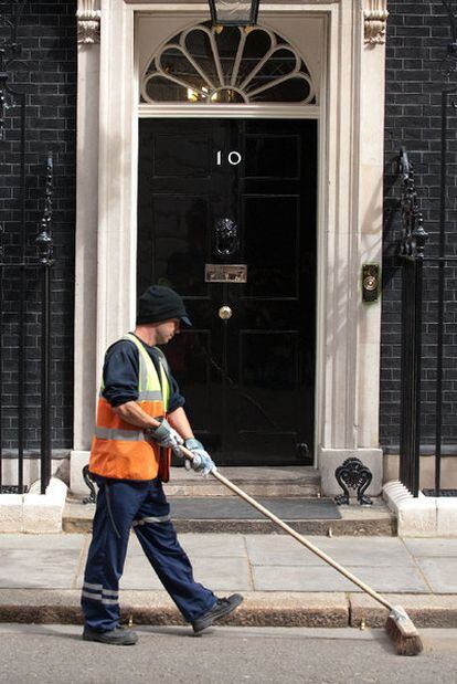 Un trabajador limpia la calle a la altura del número 10 de Downing Street.