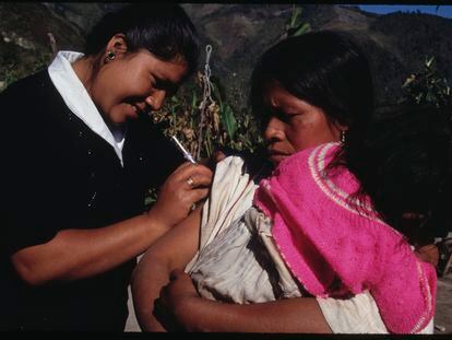 Una sanitaria vacuna a una mujer y a su hija, en una comunidad indígena de Oaxaca (México), en 1994.