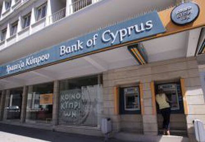Una cliente saca efectivo en el cajero autom&aacute;tico de una sucursal del Banco de Chipre, en Nicosia.
