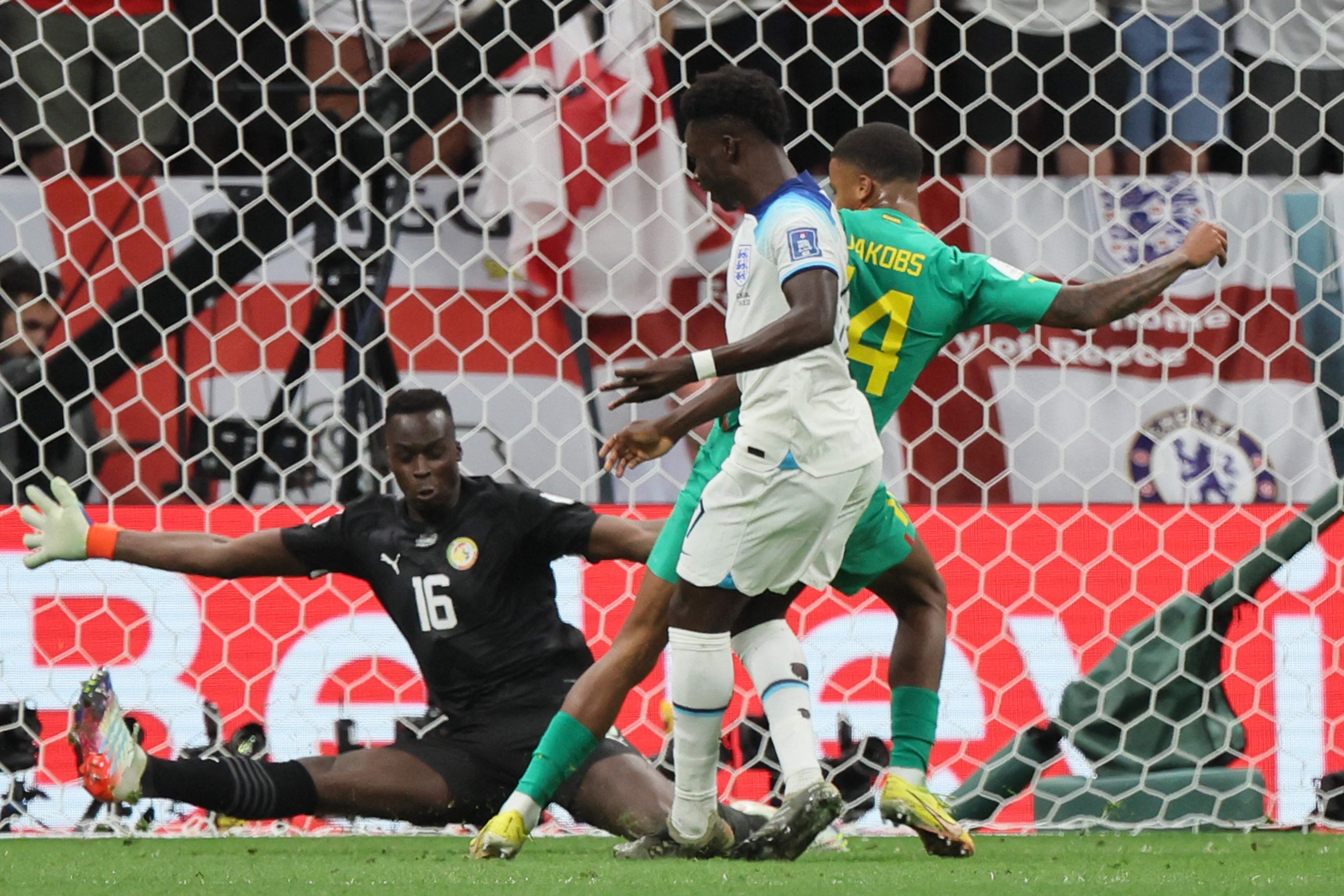 El inglés Bukayo Saka marca el tercer gol de su selección ante la infructuosa del portero sengalés Edouard Mendy, 
