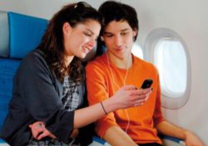 Pasajeros de avión con un móvil.