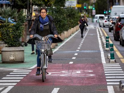 Una mujer circula por un carril bici protegido en Valencia.