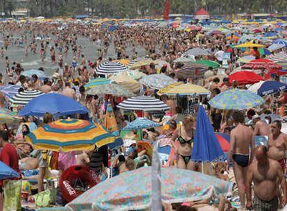 Una playa del Levante atestada de gente en pleno verano, algo que no todos podrán disfrutar