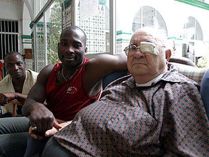 A la derecha, Ángel Rodríguez, párroco de la iglesia de San José Obrero (Málaga), junto a dos inmigrantes.