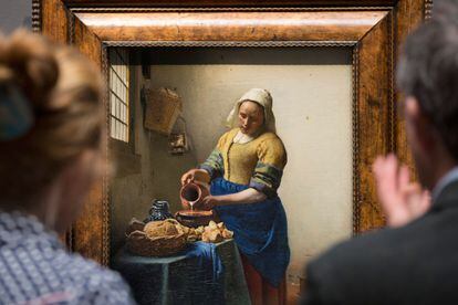 Dos visitantes en el Rijksmuseum de Ámsterdam observan el cuadro 'La lechera', de Vermeer.